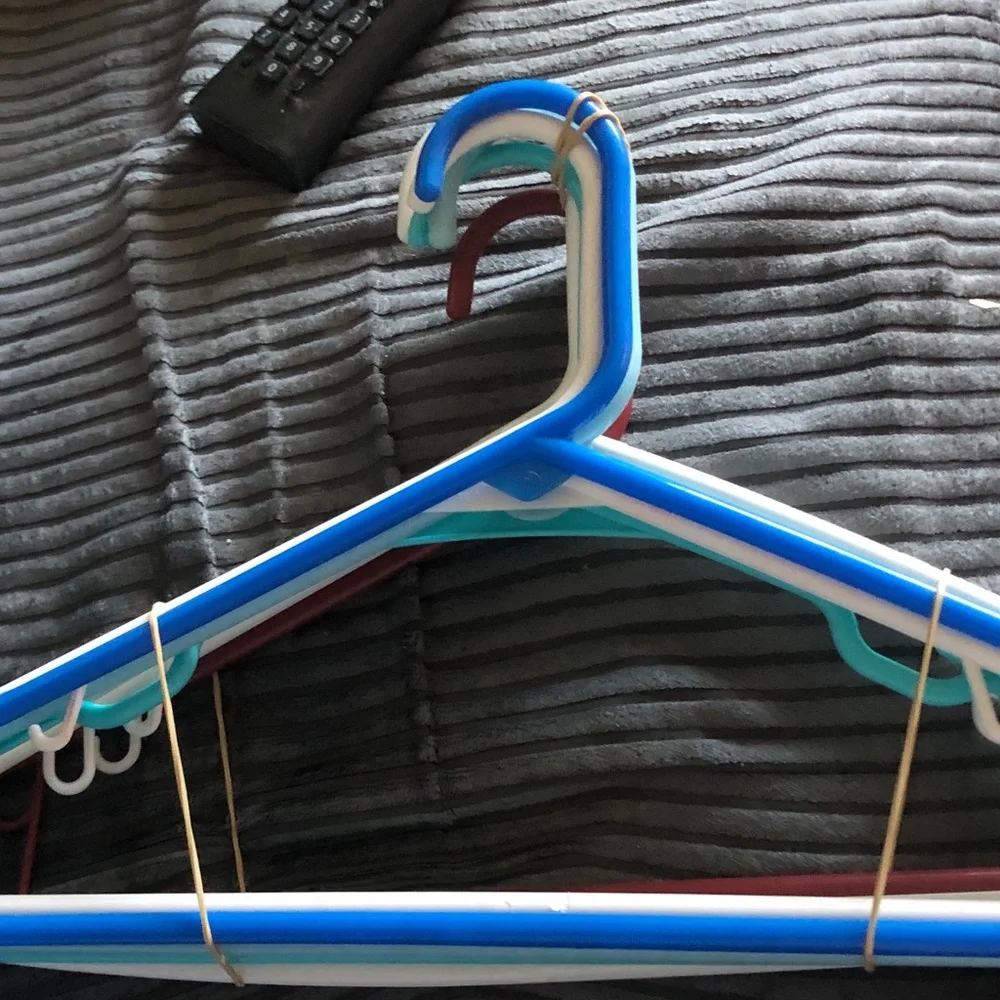 Assorted Plastic Clothing Hangers in Blue, White, Teal, and Burgundy